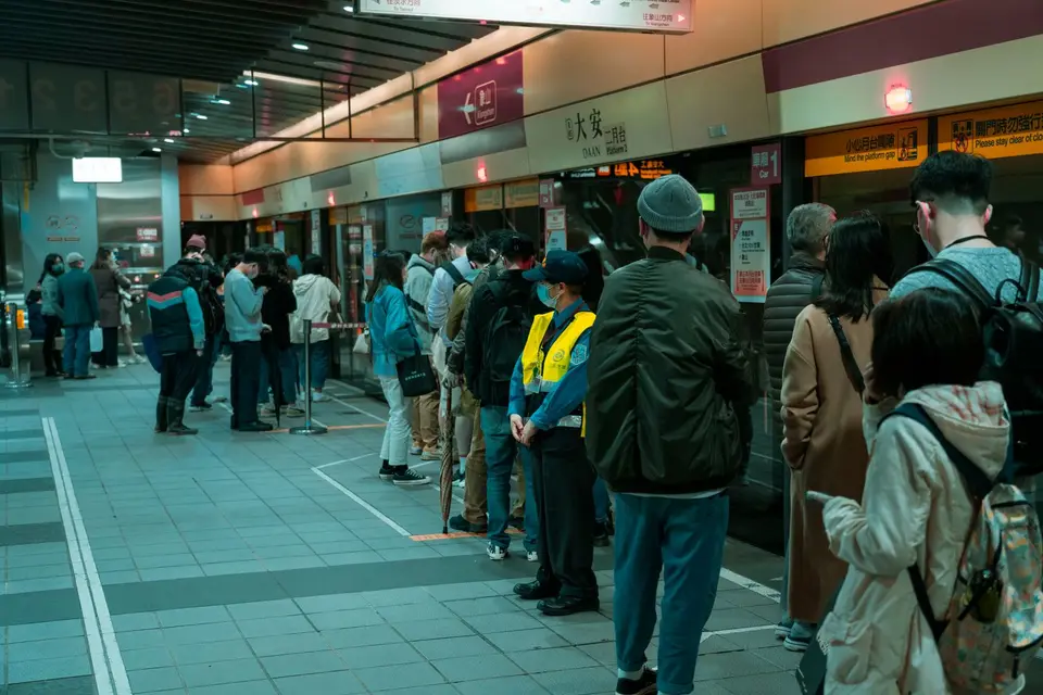 Commuters standing in neat lines on a subway platform