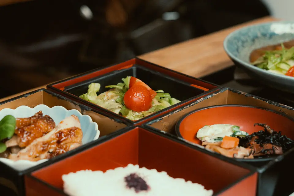 A Japanese bento box with a variety of small dishes