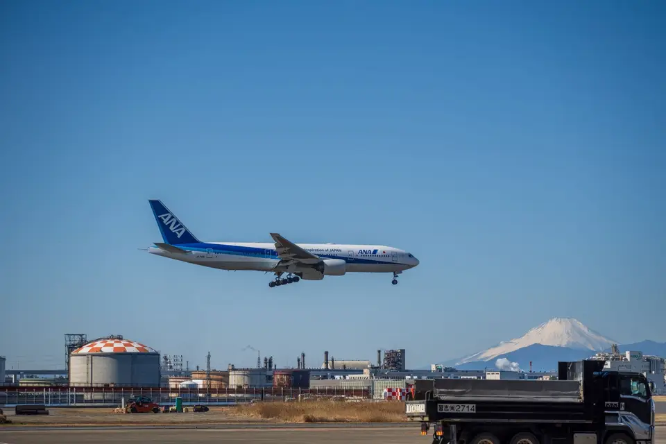 A plane coming in to land with Mount Fuji in the background