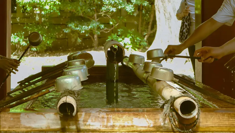 Bamboo ladles resting on a stone water basin at a Shinto shrine