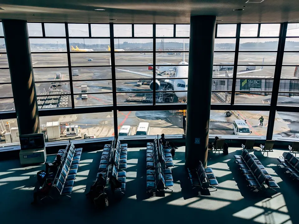 A quiet airport terminal in Tokyo with a plane outside the window