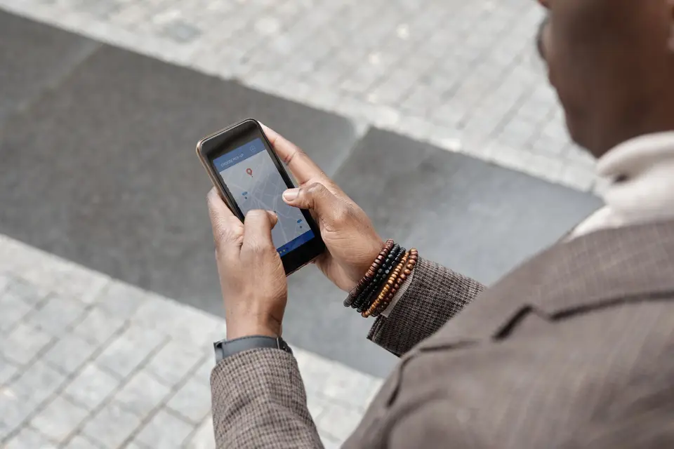 A person checking directions on a smartphone on a city pavement